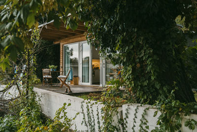 Empty porch with chairs by doorway outside house