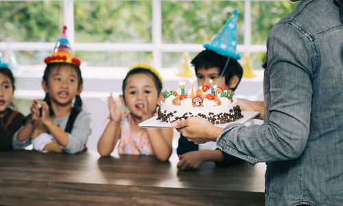 Cute happy friends enjoying birthday party at home