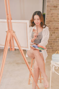 Young painter painting at home