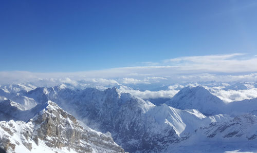 Scenic view of snowcapped mountains against blue sky