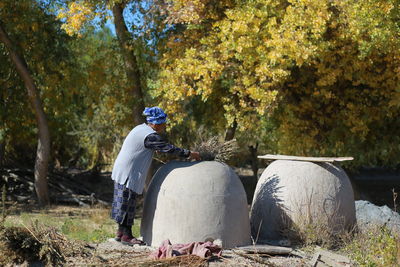 Man on field by trees in forest during autumn