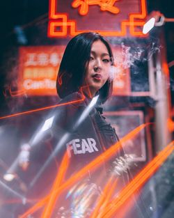 Young woman with illuminated light painting at night