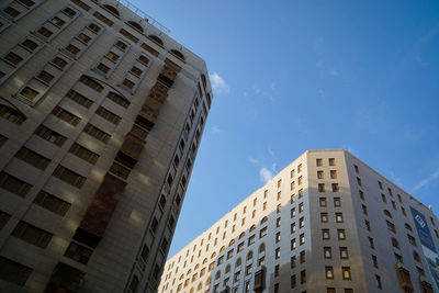 Low angle view of modern buildings against blue sky