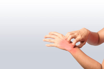 Close-up of hands over white background