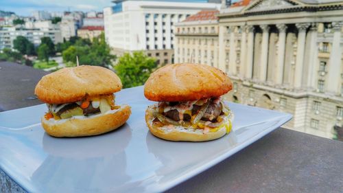 Close-up of burgers in plate on retaining wall