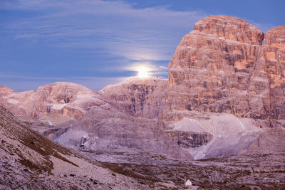 Moonrise over the mountains at sunset