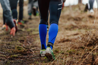 Runner legs in compression socks walking on dirty trail