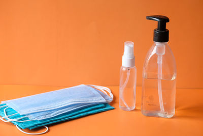 Close-up of glasses on table against orange background