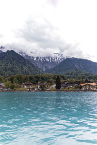 Scenic view of lake by mountains against sky