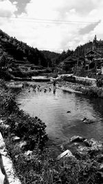 People on shore against sky