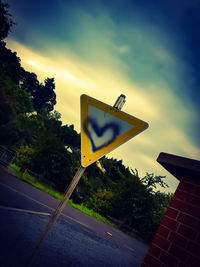 Low angle view of road sign against sky