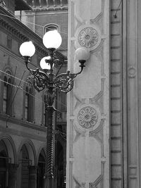 Low angle view of illuminated street light against building