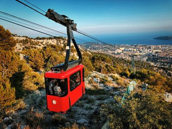 Overhead cable car on road against sky