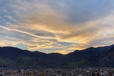 Town by mountains against sky during sunset