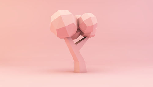 Close-up of figurine against pink background