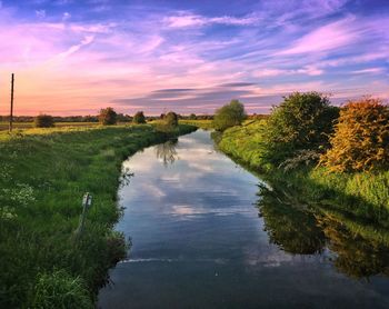 Scenic view of river against sky at sunset