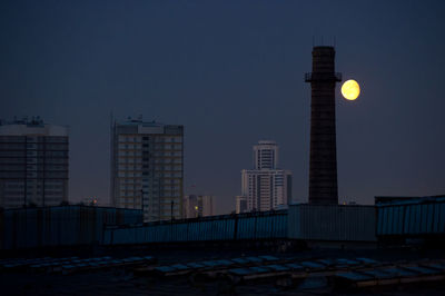 Low angle view of buildings against clear sky at night