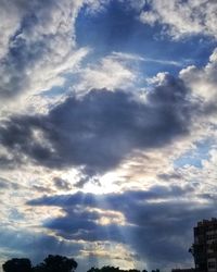 Low angle view of trees and buildings against sky