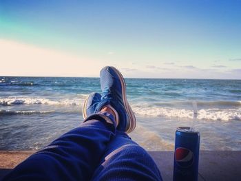 Low section of man relaxing at beach