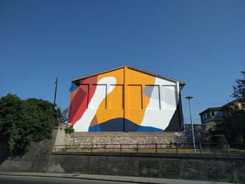 Low angle view of flag against clear blue sky