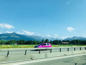 Road by mountains against blue sky