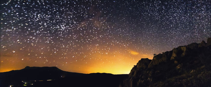 Silhouette mountain against sky at night