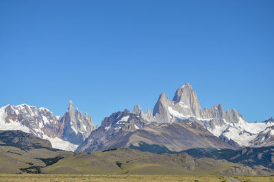 Scenic view of snowcapped mountains against clear blue sky