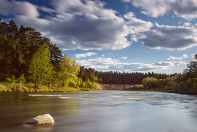 Scenic view of lake by trees against sky