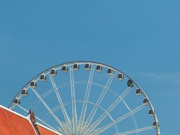 Low angle view of ferris wheel against blue sky