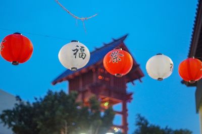 Low angle view of lanterns hanging against sky