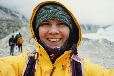Portrait of cheerful woman wearing yellow jacket during winter