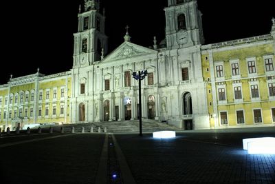 Statue in city at night