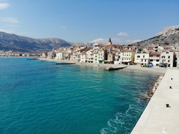 View of town by sea against sky