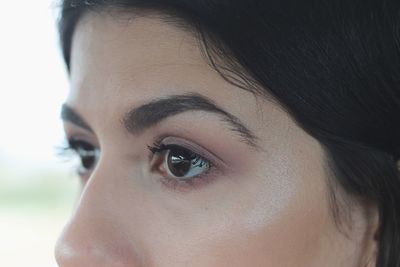 Cropped eyes of young woman looking away