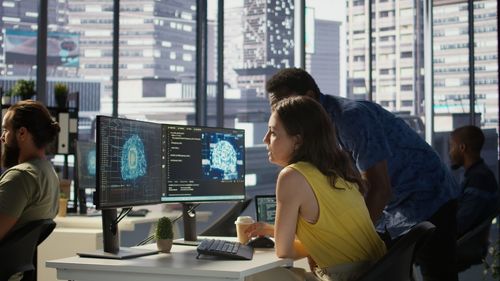 Rear view of people working at office