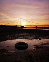 Bridge over sea against sky during sunset