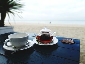 Coffee cup on table by sea