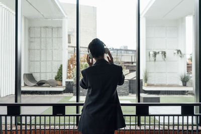 Businesswoman listening music through headphones in office