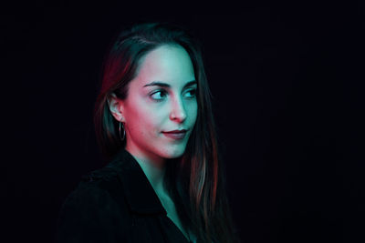 Portrait of beautiful woman against black background