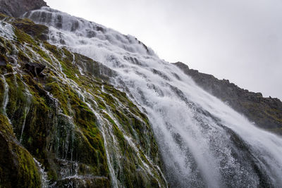 Scenic view of waterfall against sky