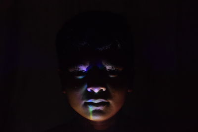 Portrait of boy against black background