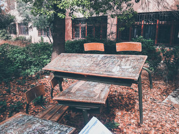 Empty bench in park against building