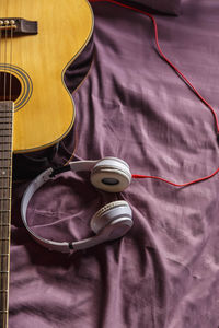 High angle view of guitar on bed