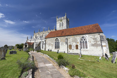 Footpath by historic building against sky