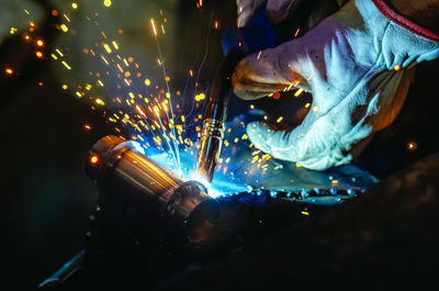 Cropped hand of man welding metal