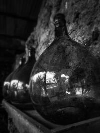 Close-up of old glass bottle against wall