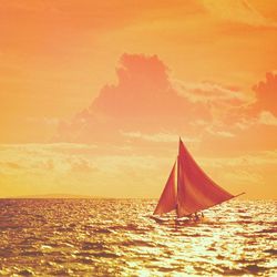 Sailboat sailing on sea against sky during sunset