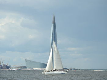 Sailboat sailing on sea against sky