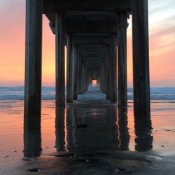 Pier on sea at sunset