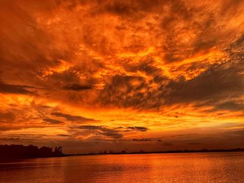 Scenic view of sea against dramatic sky during sunset